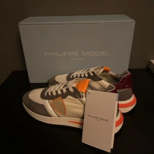 Philippe Model Trainers - Snygga Philippe Model trainers med en mix av färger som grå, vit, orange och vinröd. Skorna är perfekta till dig som vill ha stilrena skor men ändå sticka ut.                          Aldrig använda, perfekt skick.                              Stl:40 passar 41