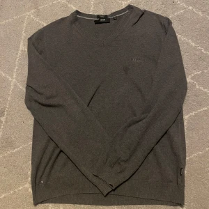 Boss V-neck tröja - Snygg grå tröja från Hugo Boss med v-ringning och broderad logga på bröstet. Perfekt som en tröja med t.ex skjorta under. Hör av er vid andra frågor 🙏✅