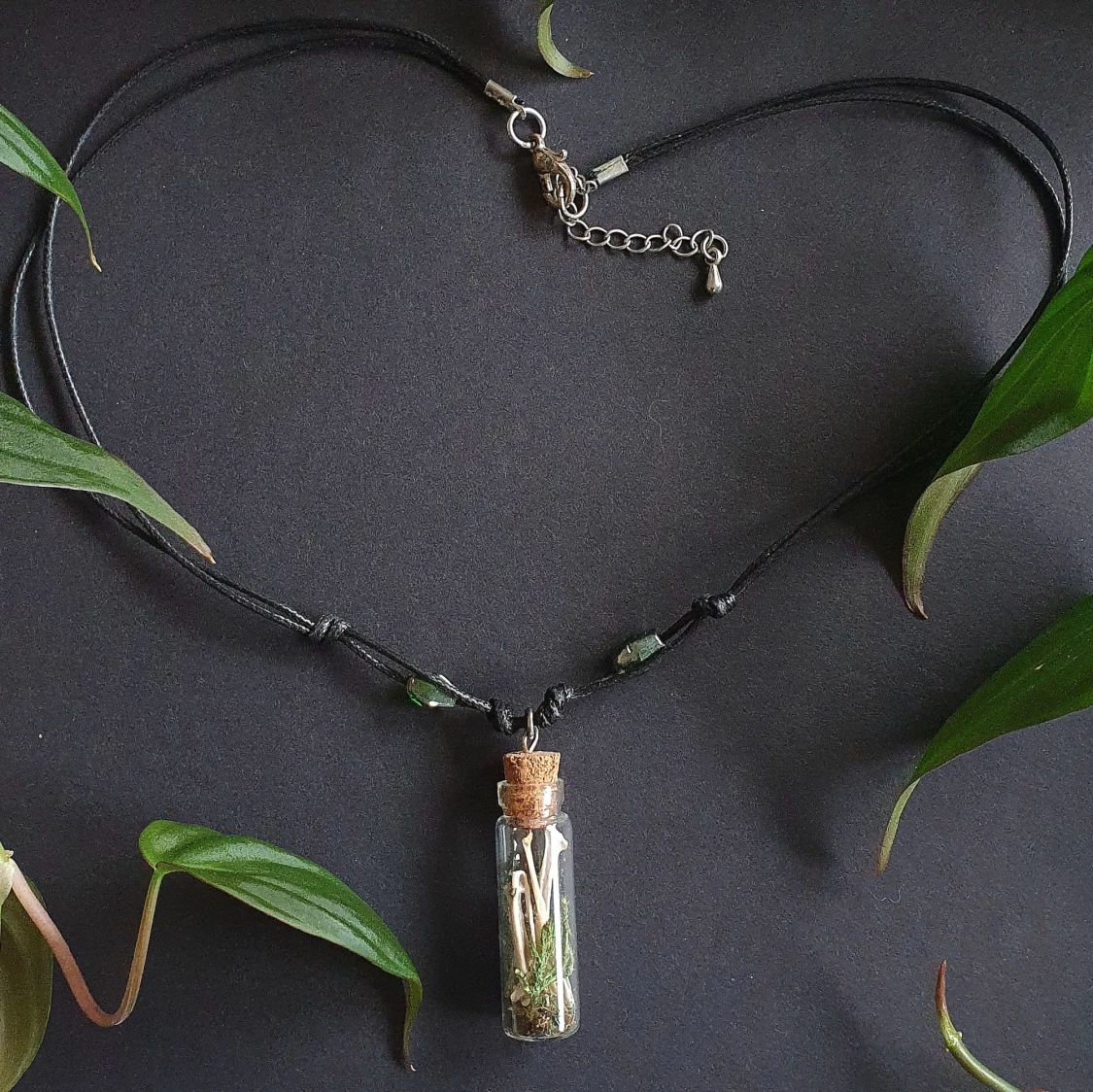 Halsband med glasflaska och naturdetaljer