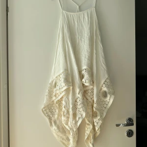 Klänning  - Letar du efter det ultimata statement-plagget för ditt nästa evenemang? Sök inte längre! Vår ärmlösa, rygglösa festklänning utstrålar elegans och sofistikering. Med sin eleganta design och smickrande silhuett är denna klänning perfekt för att göra en