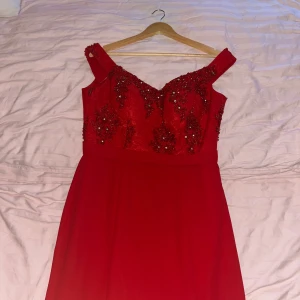 Röd festklänning - Liten i storleken (ungefär storlek 40), bara använd i några få timmar. Perfekt röd balklänning med spetsöppning i bak och paljetter på överkroppen. Okänt märke, köpt i turkiet.