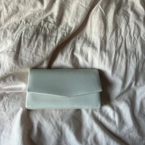 Liten väska  - En liten vit hand väska som funkar perfekt till bal, bröllop, dop eller andra fina tillställningar.  Det ingår en silvermedalj som man kan sätta på och den är djup och fräsch inuti🥰