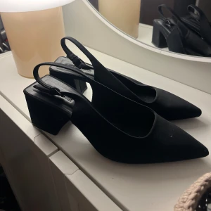 Svarta klackskor - Svarta bekväma slingbacks med fyrkantig klack från Stradivarius säljs för 200kr! Använda men i fint skick! Storlek 39💕