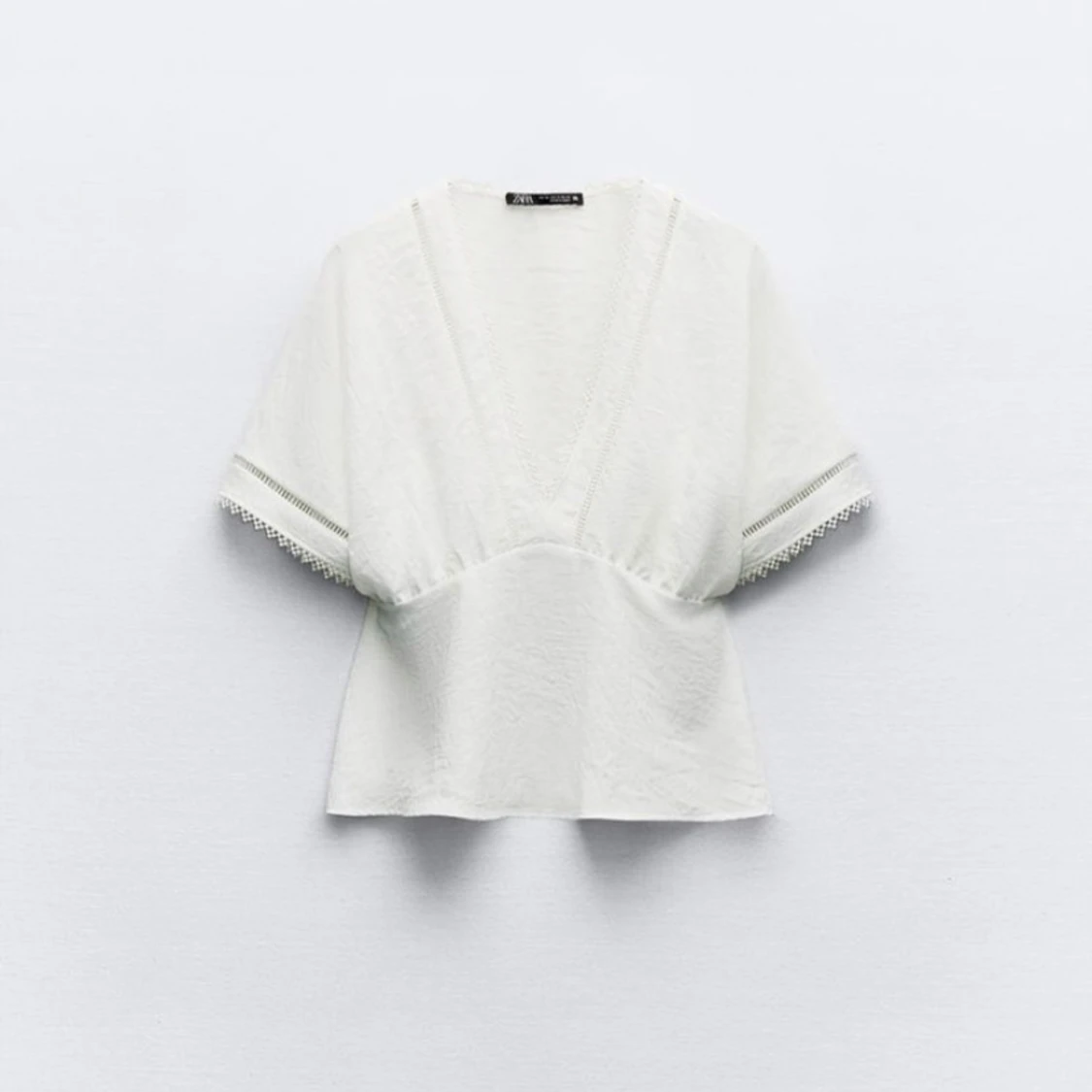 Vit blus med spetsdetaljer