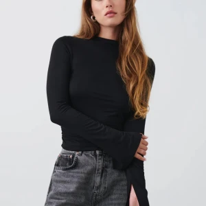 Svart långärmad tröja  - Superfin svart långärmad tröja med slits vid ärmarna. Passar perfekt till ett par jeans nu på hösten! 