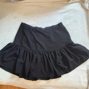 Svart kort kjol - Jättefin kjol som inte används längre. Lite volangaktig, storlek M. Köparen står för frakten<e