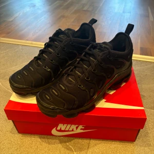 Svarta Nike Air Vapormax - Hjälper sambon att sälja ett par av hans skor. Dom är varsamt använda och är i fint skick! Finns inga större skavanker förutom några små repor fram på sulan. Är även lite utnötta på tyget vid hälen.