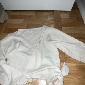 Vit omlottkofta från Even&odd - Säljer en superfin vit omlottkofta från Even & odd . Den är i ett mjukt och bekvämt material, perfekt för både vardag och fest. Koftan har långa ärmar och ett knytband i midjan för en snygg passform. Passar perfekt till höst och vår!