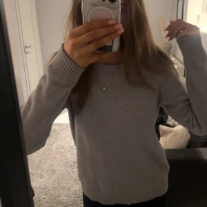 Grå stickad tröja - Säljer en supermysig grå stickad tröja från VILA Perfekt för kyliga dagar med sin mjuka och bekväma passform. Tröjan har långa ärmar och ribbade muddar vid ärmslut och nederkant. Passar perfekt till både jeans och kjol!