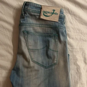 Ljusblå jeans från Jacob Cohën - Säljer ett par snygga ljusblå jeans från Jacob Cohen! Slimfit passform och bra skick utan några skador/fläckar! Många feta detaljer som väldigt små lätta slitningar som bara gör dom ännu fetare. Passar dig som är mellan 170-185. Hör av er vid frågor 🙏🏼