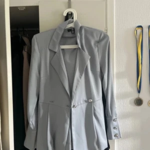 Ljusblå kavaj - Säljer en stilren ljusnblp kavaj. Aldrig använd. Den har en klassisk design med knappar framtill och en elegant krage. Perfekt för både vardag och festliga tillfällen. Passar bra till höst och vår. 🕊️