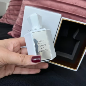 Heaven of Coconut parfym från Clair de Lune - Säljer en lyxig parfymflaska från Clair de Lune med doften Heaven of Coconut. Flaskan är vit och har en elegant, geometrisk design med en matchande vit kork. Förpackningen är stilren med månfaser tryckta på locket. Perfekt för dig som älskar kokosdoft! 🌙🥥En krämig kokos parfym, endast testad fåtal gånger. Toppnot- coconut milk, caramel. Hjärtnot- musk, sand, lotus. Basnot- vanilla, coconut, lily of the valley. Nypris- 1200kr, finns bara på en hemsida.  Heaven Of Coconut combin