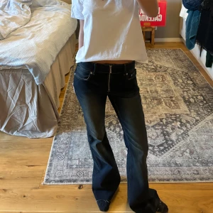 Mörkblåa bootcut jeans - Säljer ett par snygga mörkblåa bootcut jeans i bra skick. De är lågmidjade och har en klassisk dragkedja framtill. Perfekta för både vardag och fest! 🖤använda en gång och från Weekday! Avklippta så de passar nån som är ca 164
