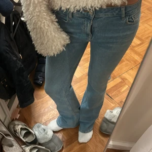 Blå bootcut jeans - Säljer ett par snygga blå bootcut jeans i mycket bra skick. De är lågmidjade/mid och har en dragkedja och knapp. Perfekta för både vardag och fest! Passar bra till en mysig tröja eller en stilren topp.