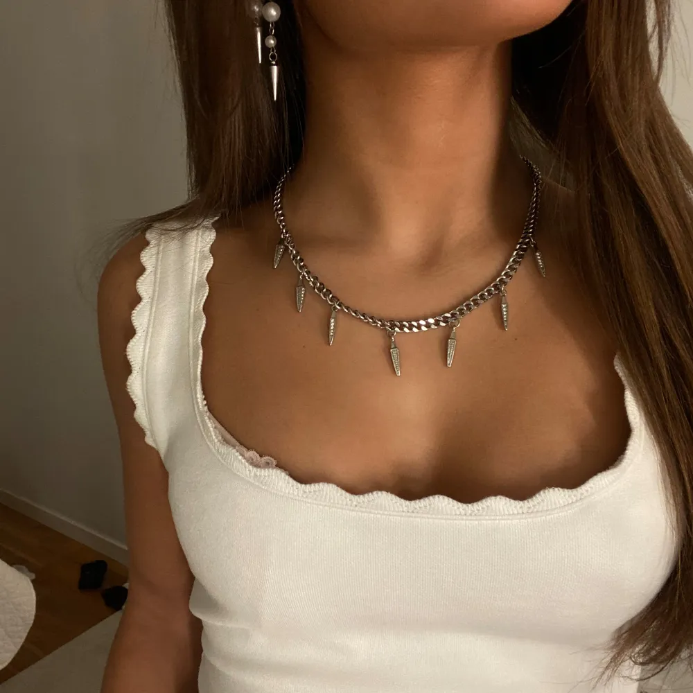 Snyggt silverfärgat halsband med coola spetsiga detaljer som ger en edgy look. Perfekt för att piffa upp en enkel outfit eller för en utekväll. Halsbandet har en kedjedesign som gör det både trendigt och stilrent🩵🩵. Accessoarer.