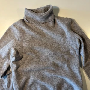 Grå polotröja från United Colors of Benetton - Mysig grå polotröja från United Colors of Benetton i 100% merinoull. En klassisk och stilren design som passar till det mesta. 🧣