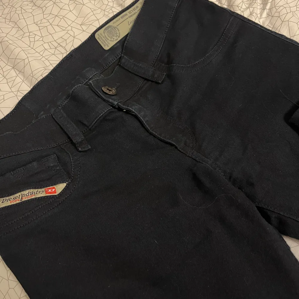 Säljer ett par supersnygga svarta low waist jeans från Diesel i bootbut. De är i stretchmaterial vilket gör dem bekväma att bära. Perfekta för både vardag och fest! 🖤. Jeans & Byxor.