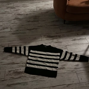 Randig stickad tröja från Gina Tricot - Säljer en superfin svart och vit randig stickad tröja från Gina Tricot. Perfekt för höst och vinter med sina långa ärmar och mysiga material. Tröjan har en klassisk design med breda ränder och ribbade kanter. Passar perfekt för en avslappnad stil eller en dag i skolan. 🖤🤍