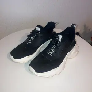 Säljer ett par snygga svarta sneakers med vit sula. De har en cool design med snörning och en bred, bekväm sula, lite smutsig sula på grund av fåtal användningar. Perfekta för vardagsbruk eller träning. Skorna är i bra skick och redo för nya äventyr! Lite små i storleken💕