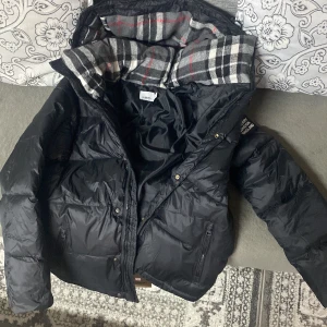Burberry jacka  - Säljer en snygg svart dunjacka från Burberry i mycket bra skick helt ny och oanvänd. Den är i storlek L, dm för mer 