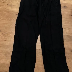 Svarta linnebyxor  - Säljer ett par svarta linnebyxor i loose fit med snörning i midjan. Från Gina tricot