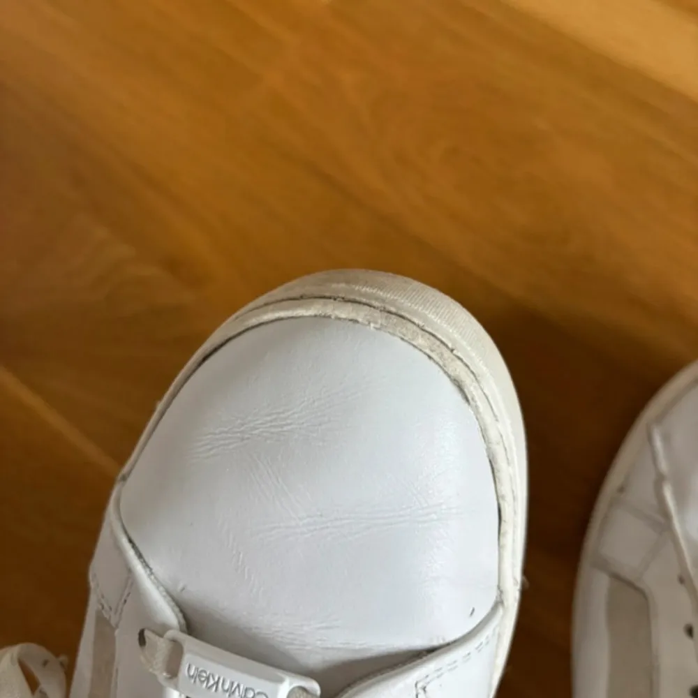 Vita Calvin Klein sneakers i storlek 39, fint skick, dock några skavanker (se bilder)! Väldigt sköna och mjuka! Inte alls gamla, nypris 1000kr. Skor.