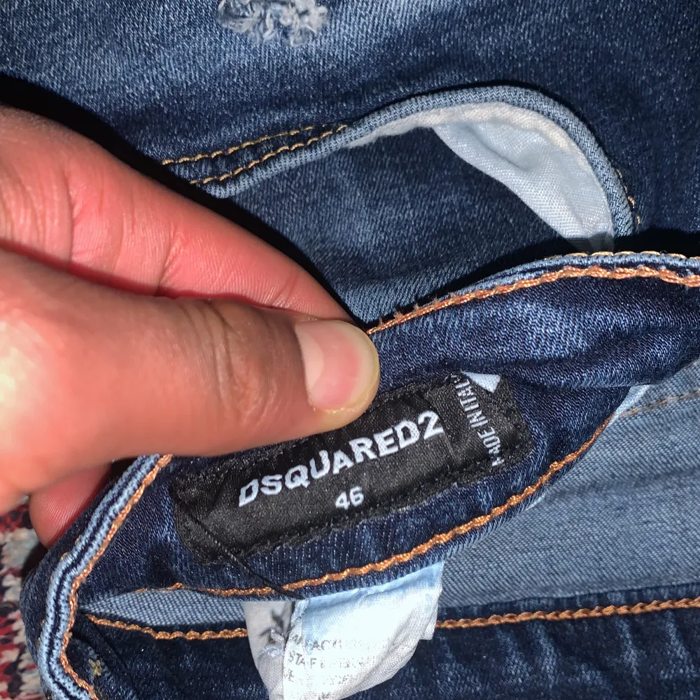 Säljer ett par snygga blå jeans från Dsquared2 i storlek 46. De har en cool slitning och distressed look som ger en edgy stil. Perfekta för en avslappnad vardagsoutfit eller en utekväll. Passformen är slim och de har en klassisk femficksdesign med knappgylf.. Jeans & Byxor.