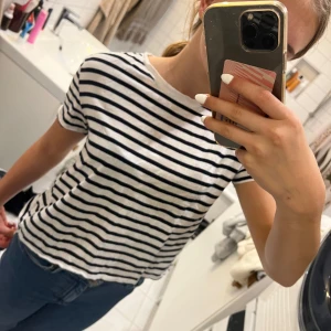 Randig t-shirt från Zara - Säljer en snygg randig t-shirt från Zara i storlek S. Den är vit med svarta ränder och har en klassisk rund hals. Perfekt för en avslappnad stil och passar till både jeans och kjol. Använd ett par gånger men i mycket bra skick! Liten i storlek❤️