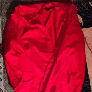 Röd halv Kimono med spetsdetaljer - Säljer en snygg röd kimono inspirerad nattkofta med vackra spetsdetaljer. Perfekt för att känna sig lyxig på kvällen eller även festliga tillfällen! Kimono har en härlig röd färg och är gjord i ett mjukt material som känns skönt mot huden. Känns som silke.