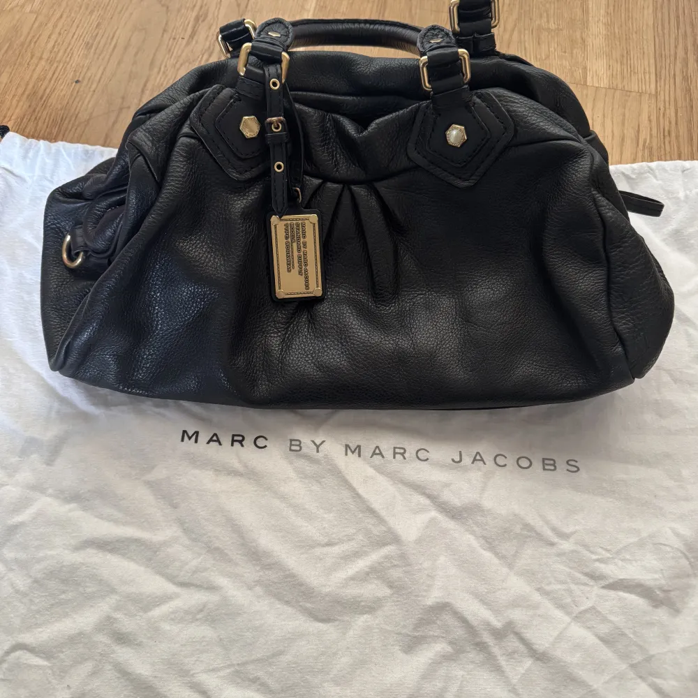 Säljer min supersnygga väska från Marc Jacobs då den inte kommer till användning längre. Enda defekten är en kaffe fläck inuti väskan annars är den som ny. Dust bag med kommer. Längd 39 cm och höjd ca 21 cm!. Laukut & Käsilaukut.