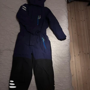 Blå overall från Isbjörn of Sweden - Säljer en blå overall från Isbjörn of Sweden i mycket bra skick. Den är perfekt för vinter och har en vattentät och andningsbar design. Overallen har dragkedja och är långärmad, med förstärkta knän och reflexdetaljer. Perfekt för att hålla sig varm och torr i alla väder!