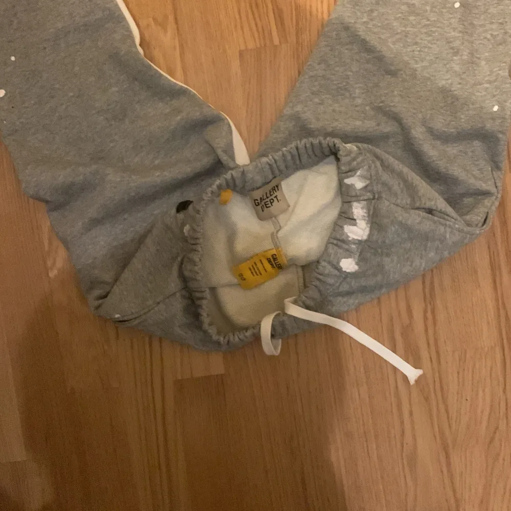 Säljer ett par grå mjukisbyxor Storlek S men sitter som Xs från Gallery Dept. med coola färgstänk och svartvita sidopaneler. Byxorna har en elastisk midja med vit snörning för bästa passform. Perfekta för en avslappnad stil eller chill dagar hemma. Tillverkade i 100% bomull för extra komfort. Pris kan diskuteras.. Farkut & Housut.