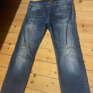 Säljer ett par snygga blå jeans från Replay i storlek 32. De har en cool sliten look med slitningar på knäna och en klassisk femficksdesign. Perfekta för en avslappnad stil. Passar både till vardags och fest! Jeansen är rätt så slitna men dom har mycket kvar att ge😁.                                                 Skriv vid funderingar🥰🤗