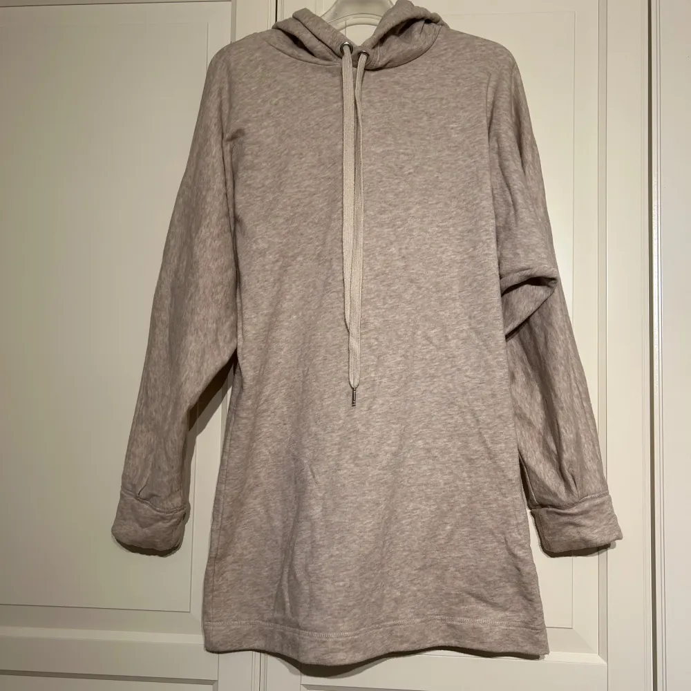 Mysig beige hoodieklänning från H&M i storlek S. Perfekt för en avslappnad stil med långa ärmar och en bekväm huva. Materialet är mjukt och skönt, idealiskt för kyligare dagar. Passar både till vardags och mysiga hemmakvällar. 🧥✨. Hoodies.