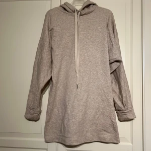 Beige hoodieklänning från H&M - Mysig beige hoodieklänning från H&M i storlek S. Perfekt för en avslappnad stil med långa ärmar och en bekväm huva. Materialet är mjukt och skönt, idealiskt för kyligare dagar. Passar både till vardags och mysiga hemmakvällar. 🧥✨