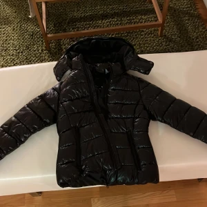 Glansig svart jacka lager 157 - Jättepopulär jacka från lager 157, svart och glansig, aldrig använd med prislappen kvar.