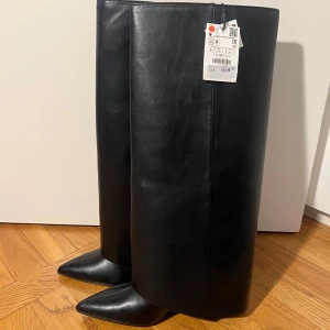 Svarta stövlar från Zara - Säljer dessa trendiga svarta stövlar i skinn med spetsig tå från Zara. Skorna är helt oanvända och är i toppskick (lappen sitter kvar)🤍                      Ny pris på skorna är 859 kr, därav säljer jag dom för ungefär samma pris då dom som sagt är helt oanvända🤍