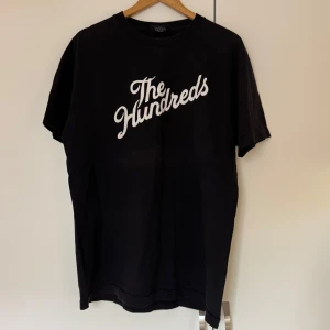 Svart t-shirt från The Hundreds - Snygg svart t-shirt från The Hundreds med vit text på framsidan. 