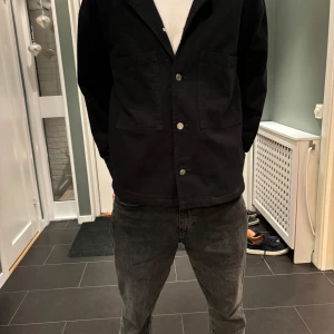 Svart overshirt från Weekday - Snygg svart overshirt från Weekday med lowkey grish stil. Perfekt för lager-på-lager-stil. Passar bra till både jeans och chinos.