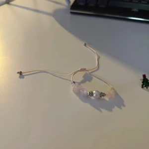 Smyckeset med armband och örhängen - Ett charmigt smyckeset med ett justerbart armband i rosa snöre och pärlor samt flera par örhängen. Örhängena inkluderar julgransmotiv, renar och blommiga mönster. Perfekt för att lägga till en festlig touch till din outfit. Allt för 40 kr