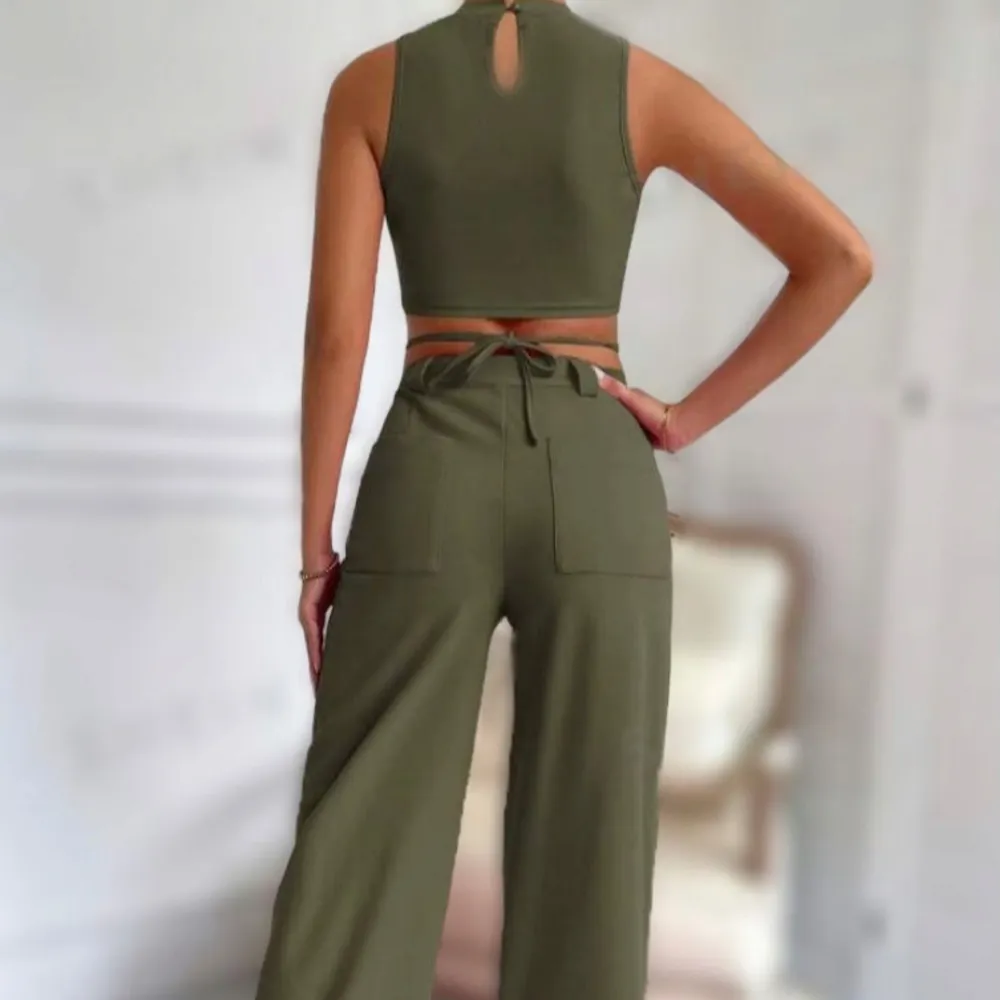 Säljer en olivgrön croppad topp/kostymbyxor från Shein med hög hals och knytband i midjan. Toppen är ärmlös och perfekt för en trendig look. Perfekt för dig som vill ha något stilrent och modernt.. Yläosat.