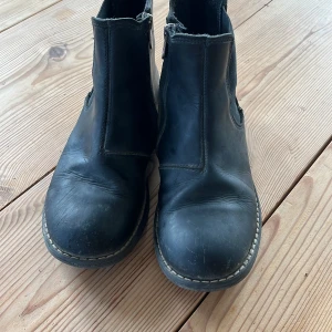 Kavat  boots med dragkedja - Säljer ett par svarta boots i skinn med dragkedja på sidan. De har en robust design och är perfekta för höst och vinter. Skorna har en rund tå och en stabil sula som ger bra grepp.
