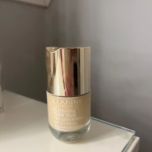 Clarins Everlasting Youth Fluid Foundation - Clarins Everlasting Youth Fluid Foundation i nyansen 103N. Denna foundation ger en strålande och jämn hudton med SPF 15. Perfekt för en naturlig look med långvarig hållbarhet. Endast testad!! Som ny! 
