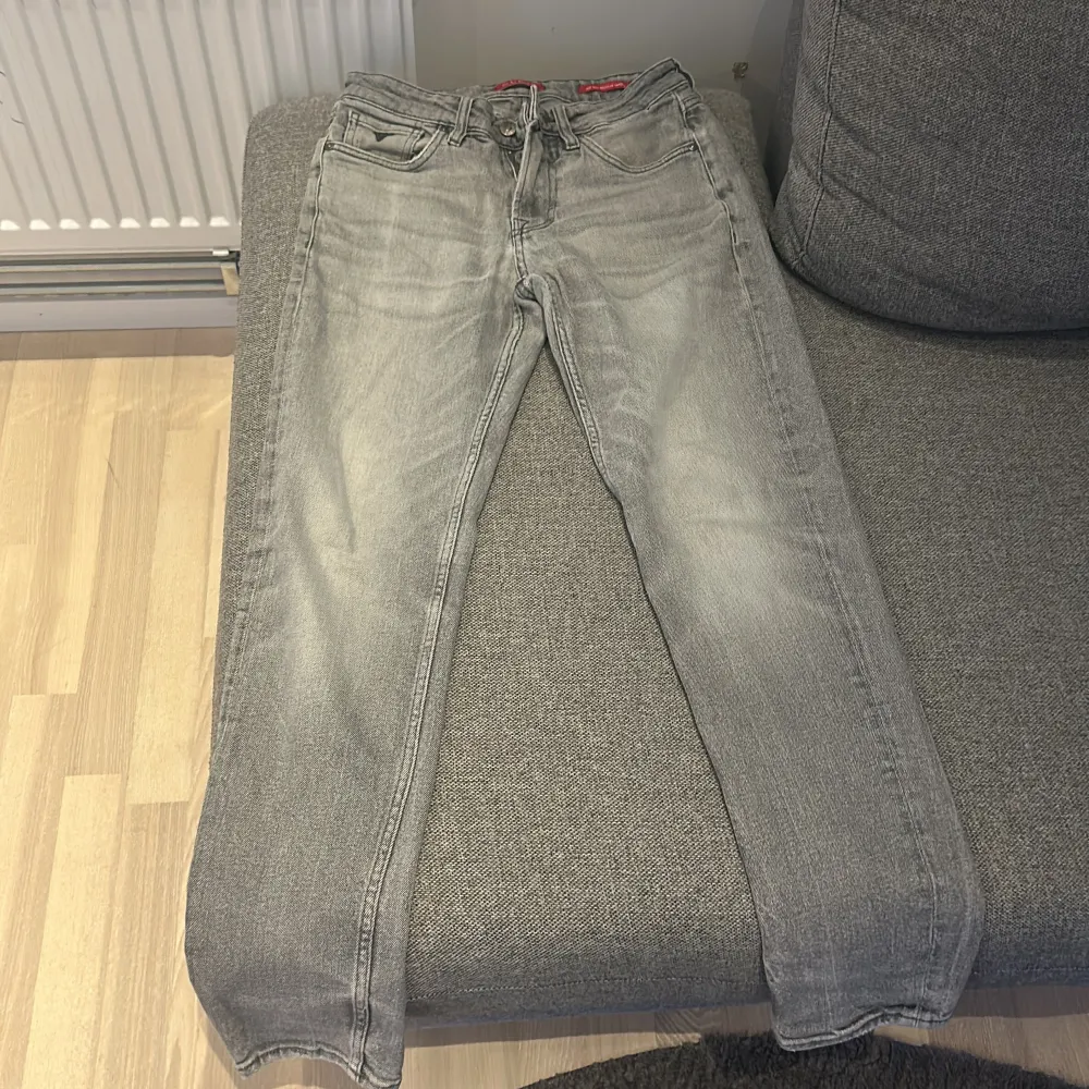 Snygga grå jeans från Guess med klassisk femficksdesign och dragkedja. De har en stilren look med märkets logga på bakfickan. Perfekta för en avslappnad stil. Använd knappast. Ny pris ligger på 900-1100. Farkut & Housut.