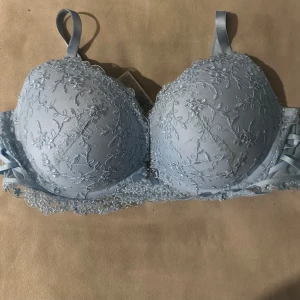 Ljusblå spets-bh från Censored - Elegant ljusblå bh med vacker spetsdetaljering från Censored. Den har justerbara axelband och en klassisk hakknäppning bak. Perfekt för en romantisk look.