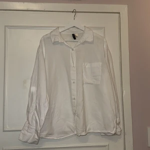 Vit skjorta från Gina Tricot - Säljer en klassisk vit skjorta i storlek L. Skjortan har långa ärmar och en bröstficka. Perfekt för en stilren look.