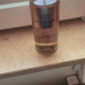 Victoria's Secret Bare Vanilla Body Mist  - Säljer en flaska Bare Vanilla body mist från Victoria's Secret. Doften har inslag av vispad vanilj och mjuk kashmir, perfekt för en fräsch och söt känsla. Flaskan är genomskinlig med en elegant etikett i guld och rosa toner. Har använt ett få tal gånger 