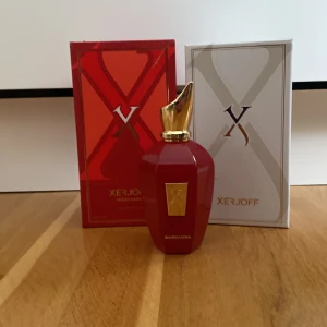 Röd parfym från Xerjoff - Elegant röd parfymflaska från Xerjoff med en gyllene kork. Flaskan har en lyxig design och kommer i en matchande röd och vit förpackning. Perfekt för den som söker en exklusiv doftupplevelse.