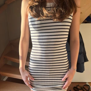 Randig ärmlös klänning - Snygg och enkel ärmlös klänning med svarta och vita ränder. Klänningen har en tight passform. Säljer eftersom den är för liten för mig💕💕