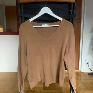 Brun tröja från H&M - Säljer en stilren brun tröja från H&M med v-ringning. Tröjan har långa ärmar och är perfekt för en avslappnad look. Passar bra till både jeans och kjol.